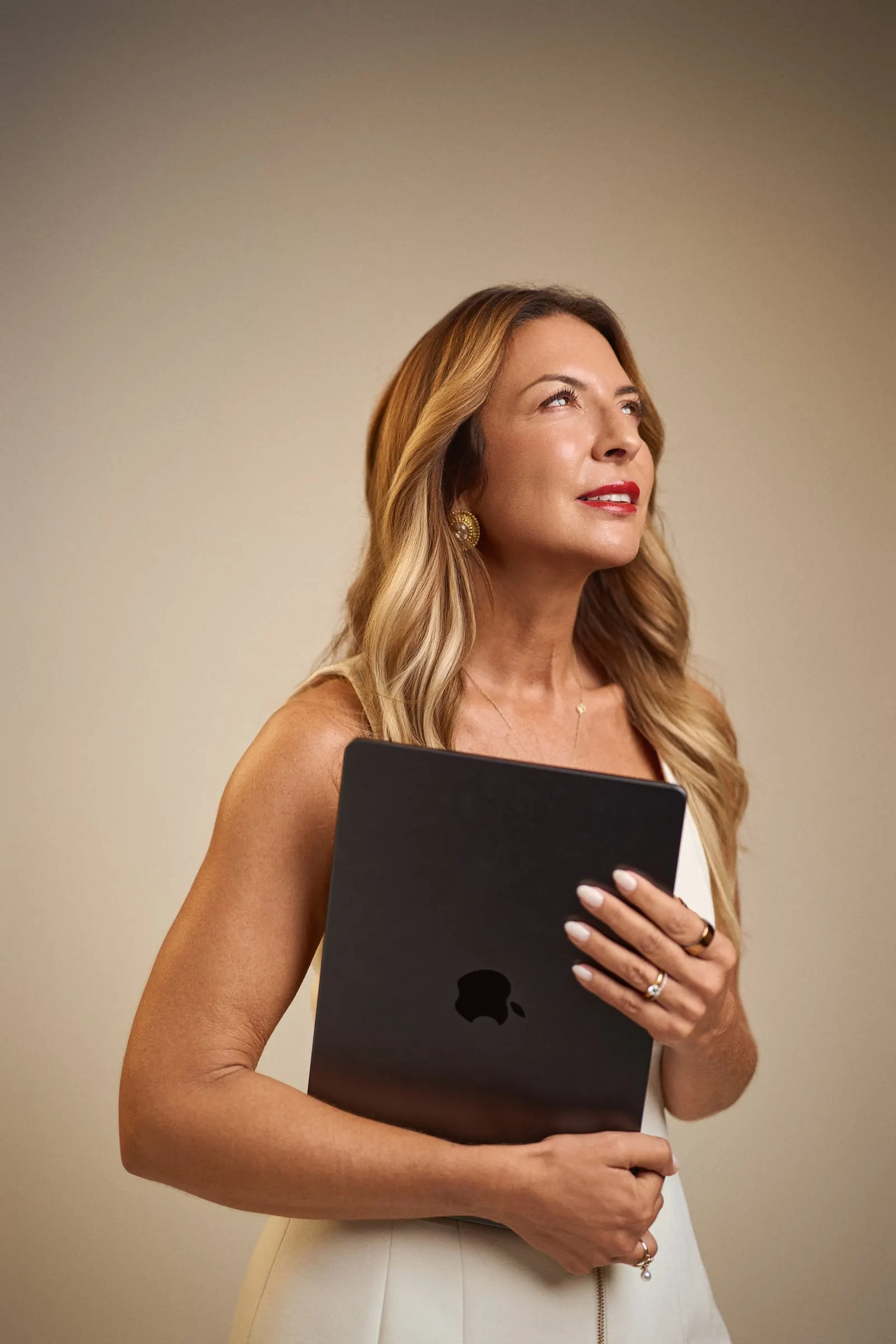 Sara Torres de pé, com um computador nos braços, a olhar para cima.