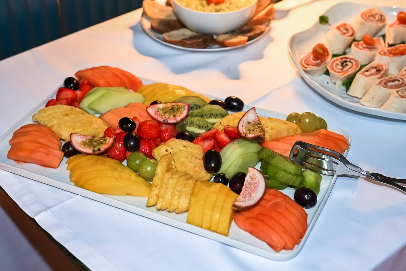 Uma travessa de fruta cortada, numa mesa de brunch.